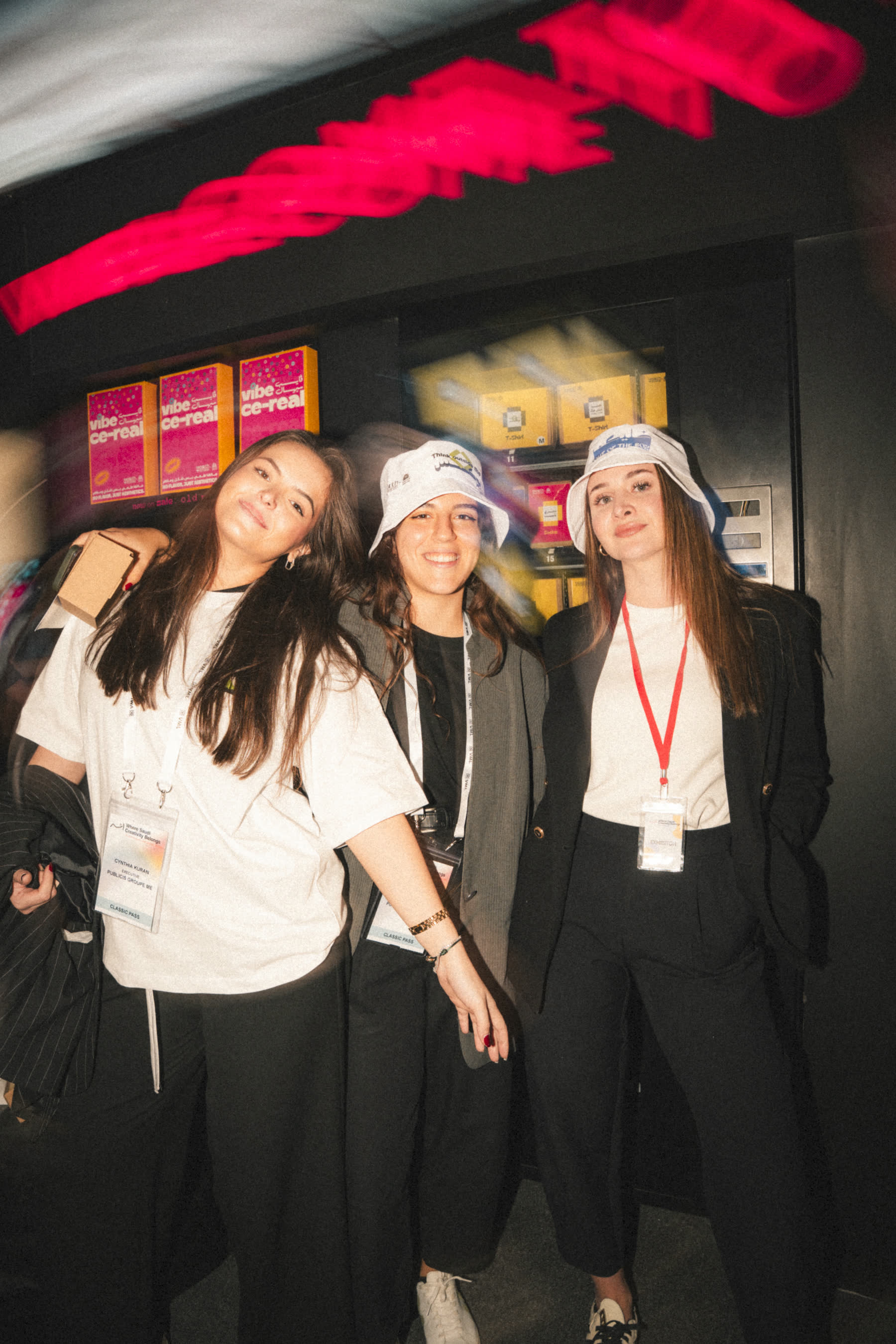 Three visitors wearing Youth Studio bucket hats
